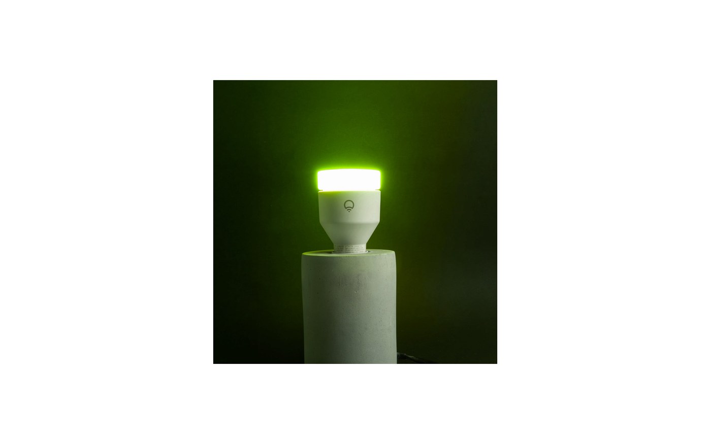 LIFX SuperColor A19 bulb glowing green on a dark pedestal
